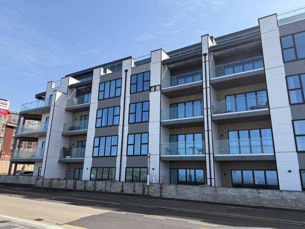 Lot: 132 - SPACIOUS TWO-BEDROOM APARTMENT WITH STUNNING SEA VIEWS AND PARKING - Front elevation taken with Tolcarne beach behind